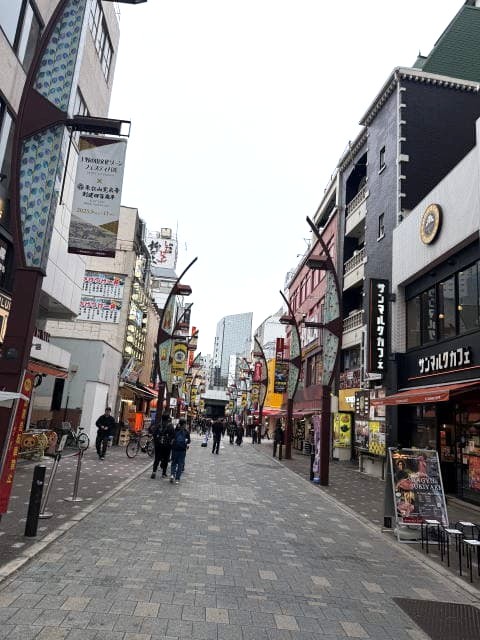 上野アメ横の広い通りとカフェ、看板が並ぶ風景
